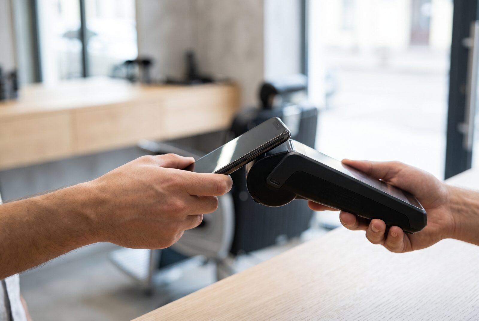 Cliente pagando por aproximação na maquininha da barbearia